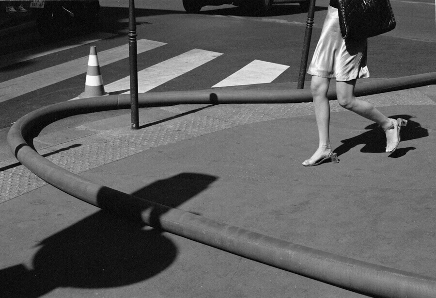 Legs and shadows of a person walking on the streets